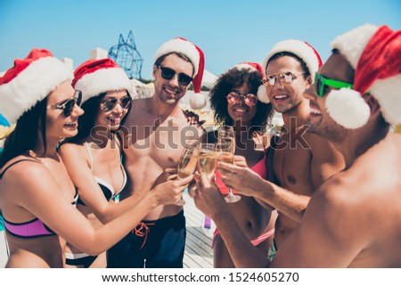 Six multiethnic race friends clink glasses celebrating new year feast at tropical resort