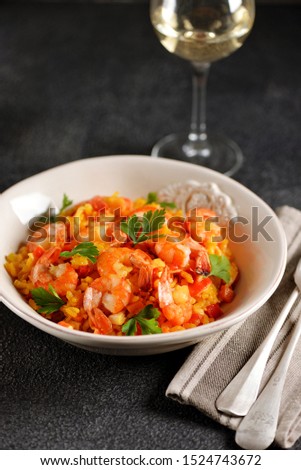 Paella or risotto with shrimp tails, carrots, onions, bell peppers, white wine and chicken stock. 