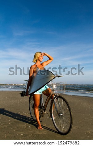 Woman on a bicycle with a surf