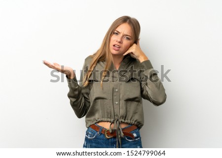 Lithuanian blonde girl over isolated white background making phone gesture and doubting