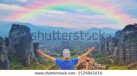 Man traveler praying at sunset mountain summit enjoying aerial epic rainbow view raised hands Travel lifestyle success relaxation. Emotional vacations, outdoor adventure freedom harmony nature concept