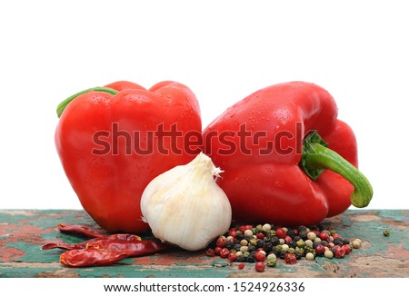 Two red capsicums, garlic and peppercorns
