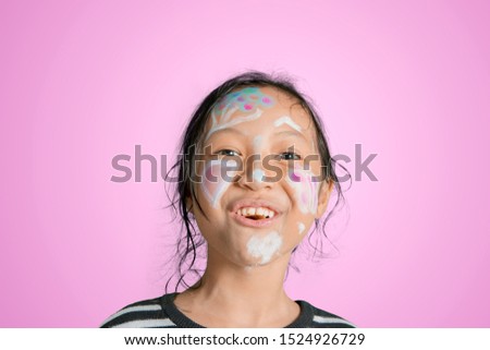 Picture of little girl smiling at the camera with face painting in the studio