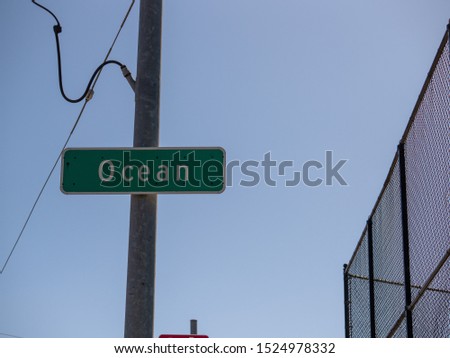 High street sign saying ocean in blue sky in a urban area