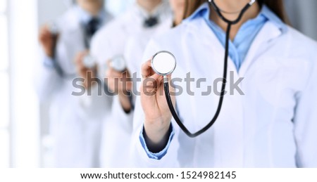 Group of doctors holding stethoscope head close-up. Physicians ready to examine and help patient. Medical help, insurance in health care, best treatment and medicine concept