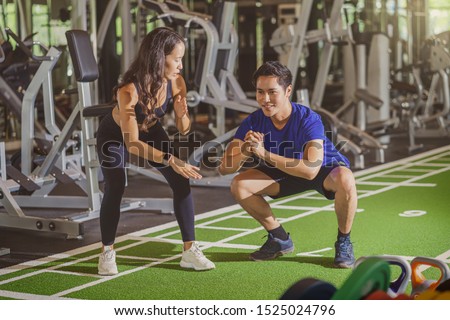 Couple young diversity working out in gym fitness sport complex, doing squad and cardio, posture position, Push up on weights, sports and healthcare,asian and asean people, concept