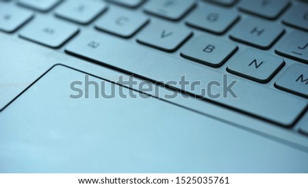Low angle view on silver touch pad and keypad of notebook