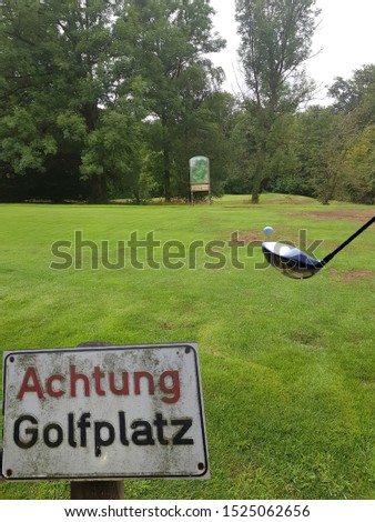 Rectangular sign with inscription in German - Caution golf course
Concept Pitch and Putt.Focus on Foreground. Background  intention noise.