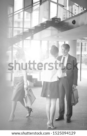 Black and white photo of businessman talking to his secretary