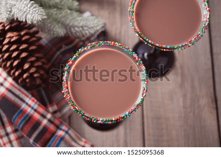 Glasses of winter season chocolate cocktail, christmas tree branch on the wooden background