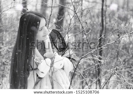 A girl in a winter cloudy day of snow-covered fields and forests
