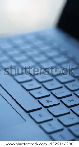 Low angle view on silver metallic keyboard of laptop by blurred background