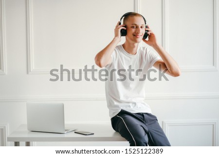 Portrait of young man with wireless headphones listening to music