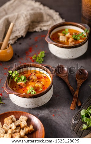 Sweet and spicy soup with crispy bread and fresh herbs