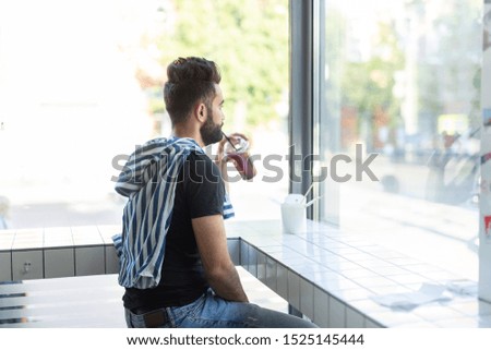 Portrait of a handsome arab man drinking smoothie in a cafe. The concept of rest and break