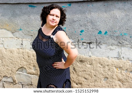 pictured in the photo owerweight woman in a black sundress white polka dots