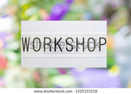 Written "workshop" on signboard whit colorful blurred background