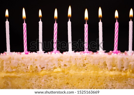 Cake with pink or pink candles for a children's birthday, black background