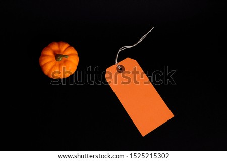 Top view of fresh whole pumpkin and price tag with copy space on black background. Top view of fresh whole pumpkin with copy space. Black Friday concept. Thanksgiving  day and Halloween concept