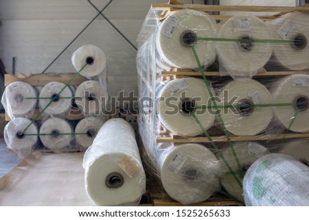 Warehouse with new plastic wrap rolls stretch packed on pallets for polycarbonate production