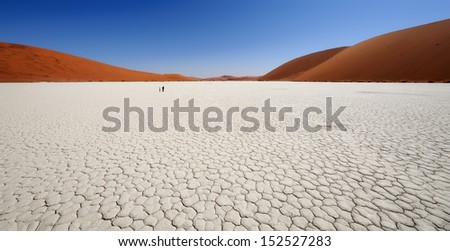 Sossusvlei (sometimes written Sossus Vlei) is a salt and clay pan surrounded by high red dunes, located in the southern part of the Namib Desert, in the Namib-Naukluft National Park of Namibia.  Royalty-Free Stock Photo #152527283