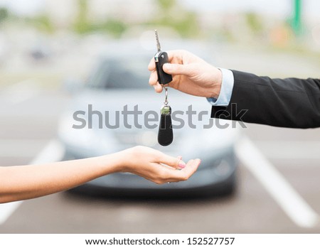 transportation and ownership concept - customer and salesman with car key outside Royalty-Free Stock Photo #152527757