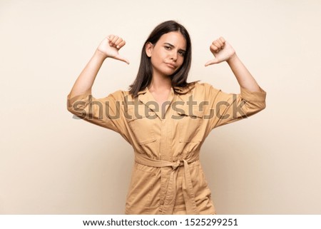 Young girl over isolated background showing thumb down