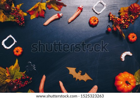 Halloween gingerbread cookies with candies on white wooden table