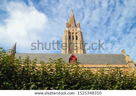 Church Of Our Lady or Onze-Lieve-Vrouwekerk in Bruges (Brugge), Belgium on blue sky background. highest building (122 metre) and the second tallest brick building in the world