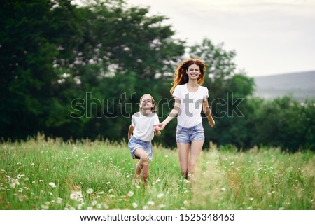 Mom and daughter hold hands walk childhood landscape of happiness