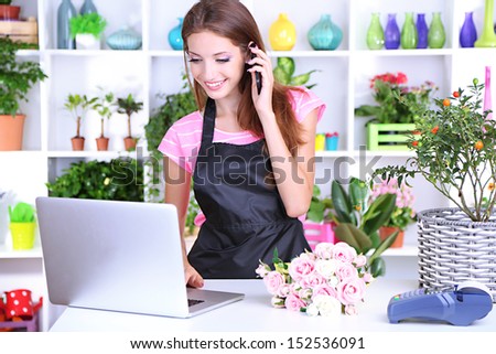 Beautiful girl florist with flowers in flowers shop 