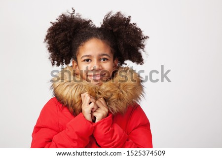 Cute teenage girl in red winter parka against white background Royalty-Free Stock Photo #1525374509