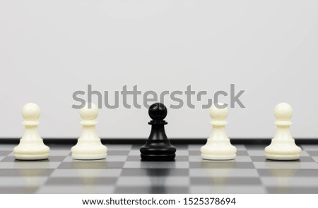 Chess piece standing out from others on light background.
Think different business unique independent concept.