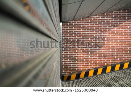 Abstract urban background with closed underground garage door and red brick wall