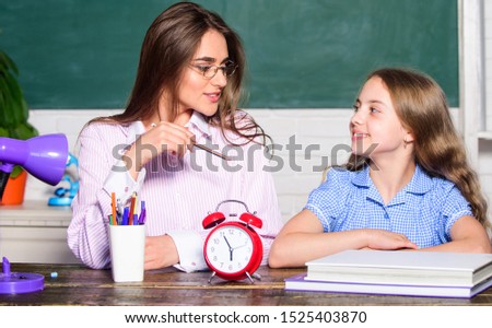 Its time to back to school. Teacher and little child at lesson. Pretty woman and small girl in school. During class time. School time. Private teaching. Education. Royalty-Free Stock Photo #1525403870