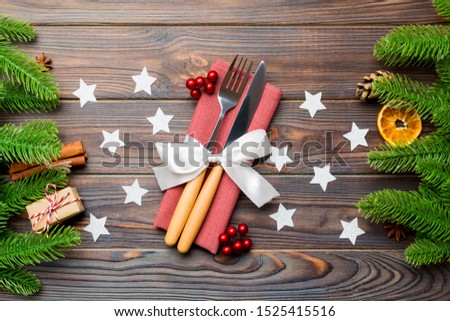Top view of utensils on festive napkin on wooden background. Christmas decorations with dried fruits and cinnamon. Close up of New year dinner concept.
