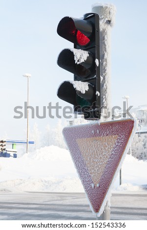 Frozen traffic light at winter showing red