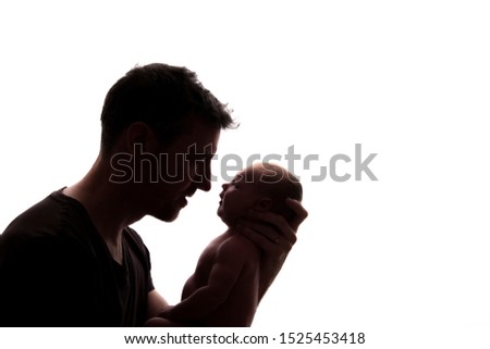 Silhouette of a father holding his newborn baby