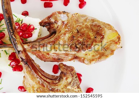 meat portion: barbecued ribs served with rice and tomatoes on plate over white background