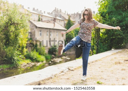Happy young woman walking alone on a summer day - Casually dressed smiling beautiful girl wearing jeans feeling good and having fun in the city - Concept image for healthy balanced lifestyle