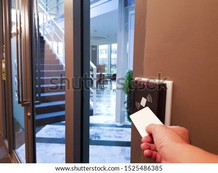 Men hand reaching to use RFID key card to access the area. In building security only for authorized person