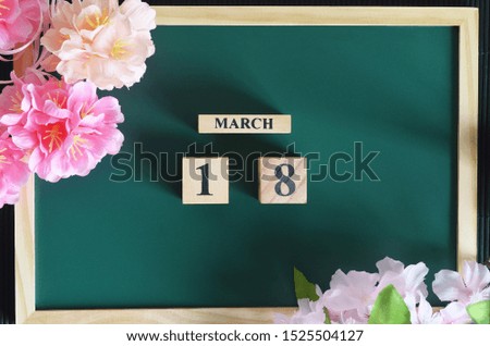 Japanese Cover, Number cube with sakura flower on the wood green board, March 18.