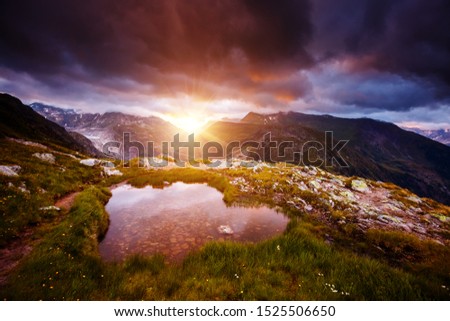Epic views of mountain slopes in the sunbeams. Location place of Totensee, Grimsel pass or Grimselpass in the canton of Valais, Swiss alps, Europe. Attractive wallpaper. Discover the beauty of earth.
