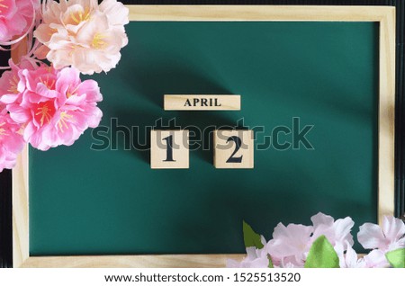 Japanese Cover, Number cube with sakura flower on the wood green board, April 12.