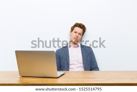 young red head businessman working in his desk with a laptop