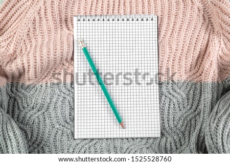 notebook on texture sweater with empty space for text. the view 