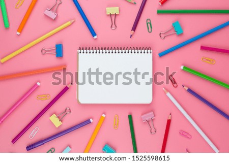 Colorful school supplies over a paper on pink background with place for your text. Stationery of different colors.  Back to school concept.