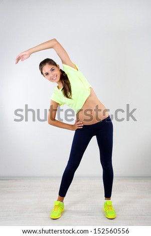 Beautiful young girl doing exercises at home