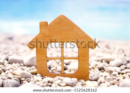 Little wooden house on the beach on a background of the sea.  Conceptual image of an eco-house, housing by the sea, rent and buy a house