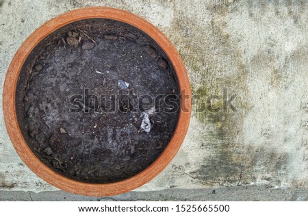 Black soil mixed with fertilizer is in a brown pot to plant trees. 